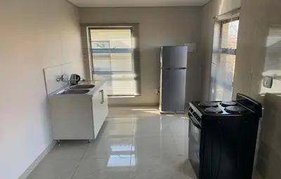 a kitchen with a stove and a sink and a refrigerator at Yami Nawe Lodge in Dennilton