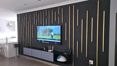 a television on a black wall with gold lines at Musanda Villa 413 Euphoria in Naboomspruit