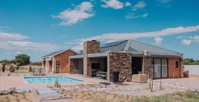 a brick house with a pool in front of it at Musanda Villa 413 Euphoria in Naboomspruit