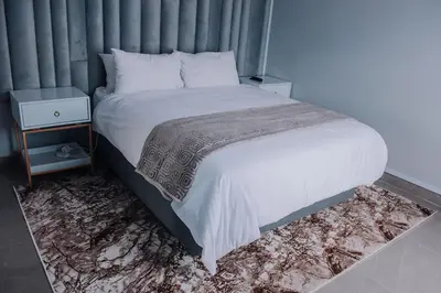 a bedroom with a large bed with white sheets and a table at Musanda Villa 413 Euphoria in Naboomspruit