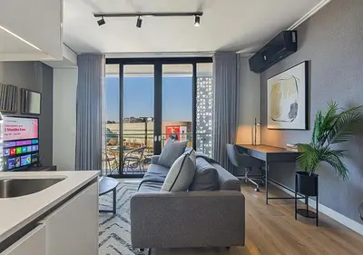 a living room with a couch and a desk at 5 Star Elegant Apartments, Ellipse, Waterfall City, Midrand, Johannesburg in Midrand