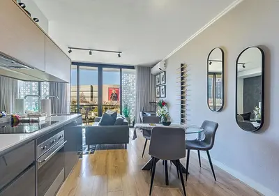 a kitchen and dining room with a table and chairs at 5 Star Elegant Apartments, Ellipse, Waterfall City, Midrand, Johannesburg in Midrand