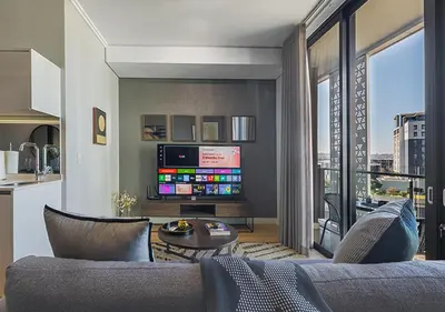 a living room with a couch and a tv at 5 Star Elegant Apartments, Ellipse, Waterfall City, Midrand, Johannesburg in Midrand