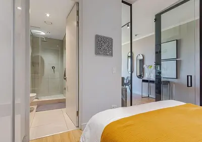 a bedroom with a bed and a bathroom with a shower at 5 Star Elegant Apartments, Ellipse, Waterfall City, Midrand, Johannesburg in Midrand