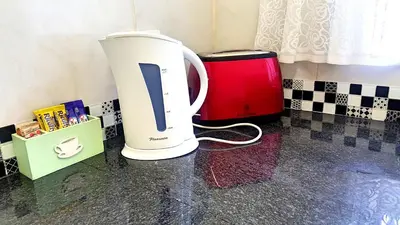 a white coffee maker sitting on a counter in a kitchen at Sunshine Self Catering in Nelspruit