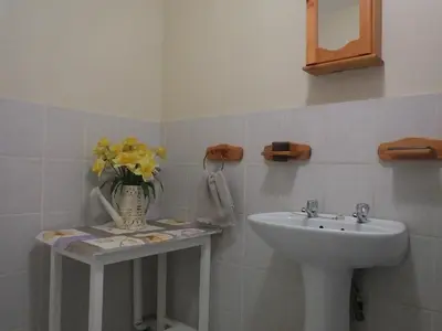 a bathroom with a sink and a vase of flowers at Sunshine Self Catering in Nelspruit