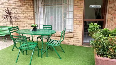 a green table and chairs on a patio at Sunshine Self Catering in Nelspruit