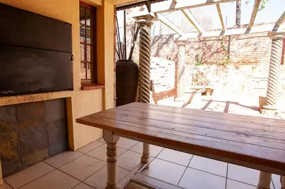 a wooden table in a room with a window at Crimson Cottage in Dullstroom