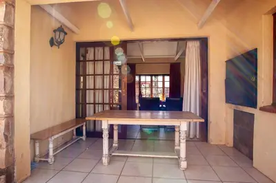 a dining room with a table and a bench at Crimson Cottage in Dullstroom