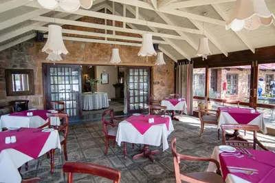 a restaurant with red and white tables and chairs at Critchley Hackle in Dullstroom