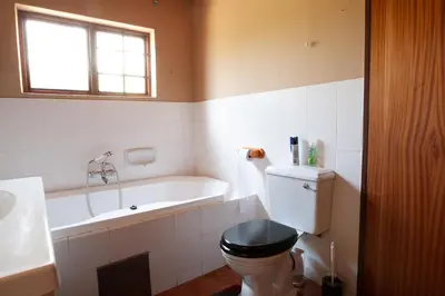 a bathroom with a toilet and a bath tub at Critchley Common in Dullstroom