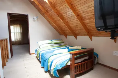 a bedroom with a bed and a flat screen tv at Critchley Common in Dullstroom