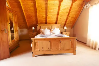 a bedroom with a large bed with a wooden ceiling at Critchley Common in Dullstroom
