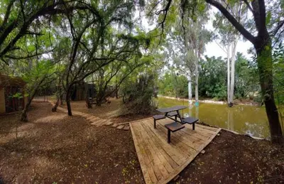 a picnic table sitting on a wooden platform next to a river at Vulture's View 5 in Hartbeespoort