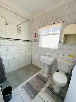 a bathroom with a toilet and a sink at The Valley, tranquil 3 bedroom home with pool in Midrand