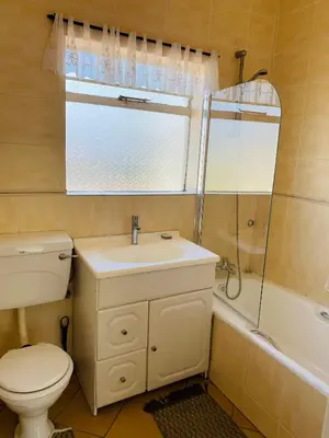 a bathroom with a toilet and a sink and a shower at The Valley, tranquil 3 bedroom home with pool in Midrand