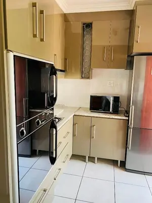 a kitchen with stainless steel appliances and white tile floors at The Valley, tranquil 3 bedroom home with pool in Midrand