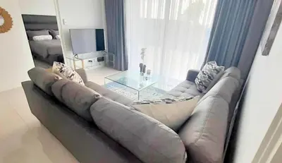 a living room with a couch and a glass table at Waterfall Luxury Apartment in Midrand