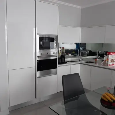 a kitchen with white cabinets and a stainless steel oven at Waterfall Luxury Apartment in Midrand