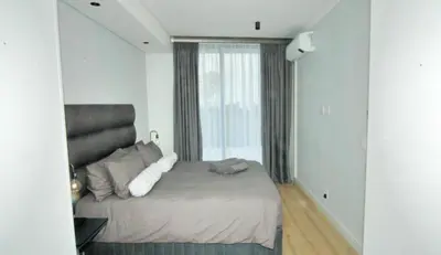 a bedroom with a bed with a large window at Waterfall Luxury Apartment in Midrand
