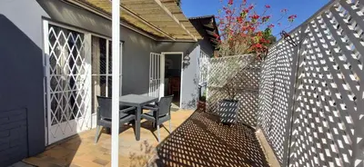 a patio with a table and chairs on a fence at 7-on-Burger in Polokwane