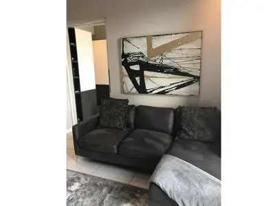a living room with a couch and a chair at Menlyn Apartment - Sapphire Gold in Pretoria