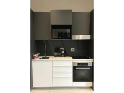 a kitchen with white cabinets and a stove top oven at Menlyn Apartment - Sapphire Gold in Pretoria