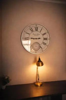 a clock hanging on the wall above a lamp at Menlyn Apartment - Sapphire Gold in Pretoria