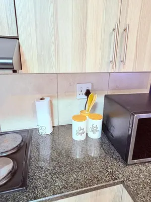 a kitchen counter with two cups and a microwave at 43 Home self Catering with backup power and High speed WiFi in Witbank
