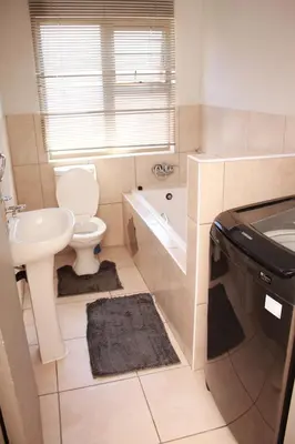 a bathroom with a sink and a toilet and a tub at 43 Home self Catering with backup power and High speed WiFi in Witbank