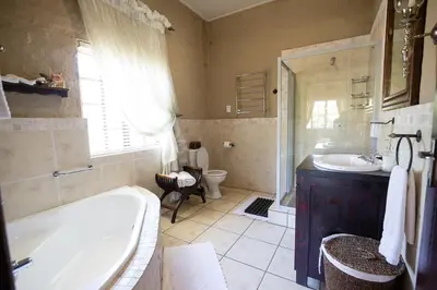 a bathroom with a tub and a sink and a toilet at Downstream in Dullstroom