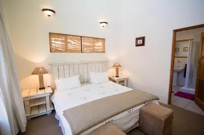 a bedroom with a bed and two tables and two lamps at Upstream in Dullstroom