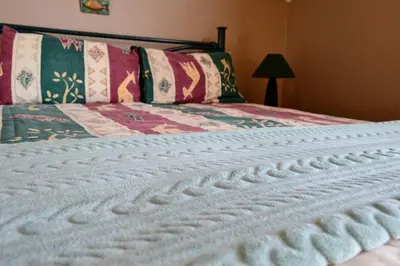 a close up of a white blanket on a bed at Upstream in Dullstroom