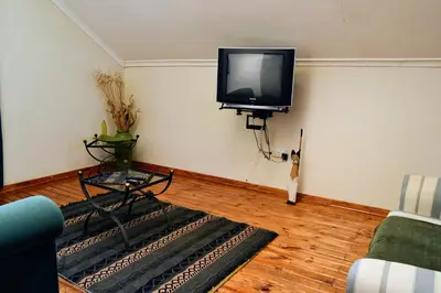 a living room with a flat screen tv on the wall at Upstream in Dullstroom