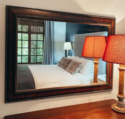 a bedroom with a large mirror above a bed at Fairstreams 4 in Dullstroom
