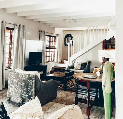 a man standing in a living room with a table at Fairstreams 4 in Dullstroom