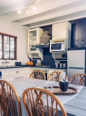 a kitchen with a table and chairs in a kitchen at Fairstreams 4 in Dullstroom