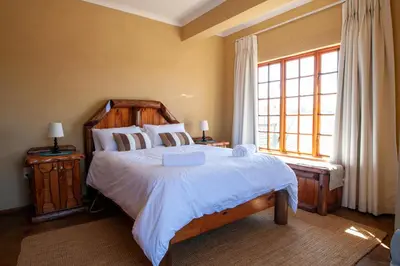a bedroom with a large bed and a window at Gecko Castle in Dullstroom