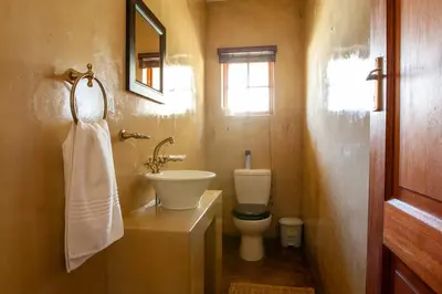 a bathroom with a sink and a toilet and a window at Gecko Castle in Dullstroom
