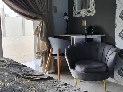a living room with a chair and a table at SEA WATER BOUTIQUE LODGE in Mankweng unit G in Polokwane