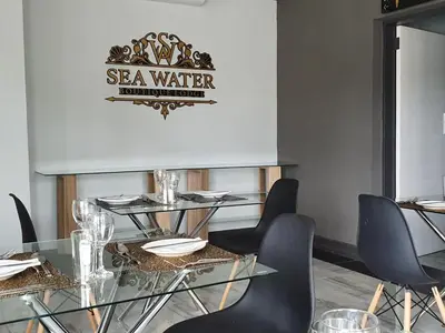a dining room with a glass table and chairs at SEA WATER BOUTIQUE LODGE in Mankweng unit G in Polokwane