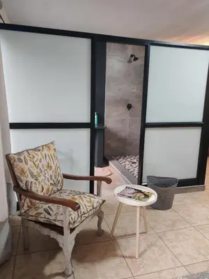 a chair and a table in a room with large windows at House Olive in Pretoria
