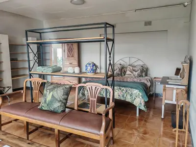 a bedroom with a bunk bed and a chair at House Olive in Pretoria