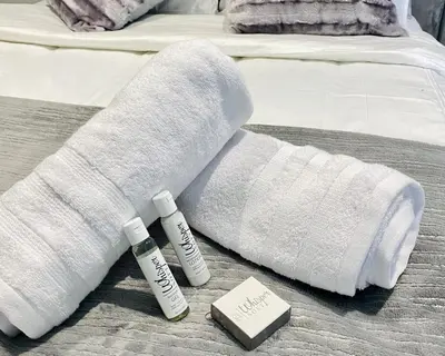 a white sock and two bottles of sunscreen on a bed at Waterfall Views From The Six- Luxurious Apartment in Midrand