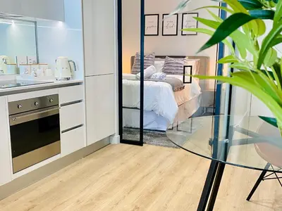 a bedroom with a bed and a glass table in a room at Waterfall Views From The Six- Luxurious Apartment in Midrand