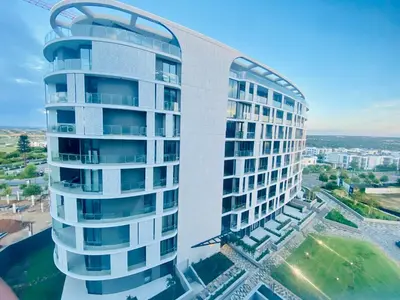a tall white building with a curved tower at Waterfall Views From The Six- Luxurious Apartment in Midrand