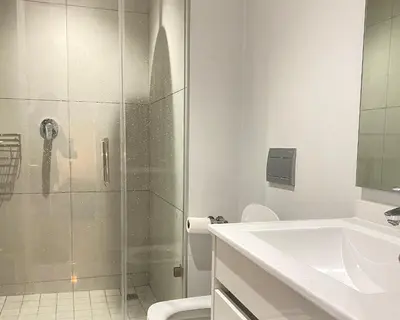 a bathroom with a shower and a toilet and a sink at Waterfall Views From The Six- Luxurious Apartment in Midrand