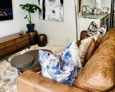 a living room with a couch and a table at Waterfall Views From The Six- Luxurious Apartment in Midrand