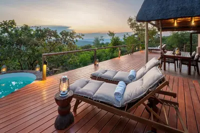 a deck with lounges and a pool on a house at Elephants Crossing in Welgevonden Game Reserve