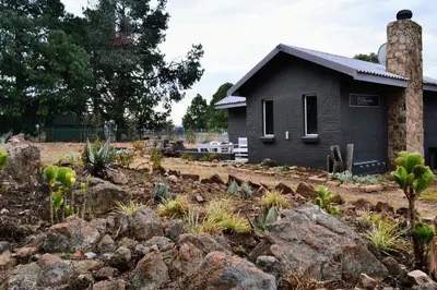 a house with a pile of rocks in front of a yard at Salt on Dullstroom in Dullstroom